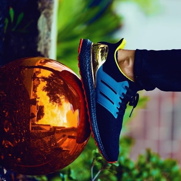 Grey soccer ball and blue and black Adidas shoe