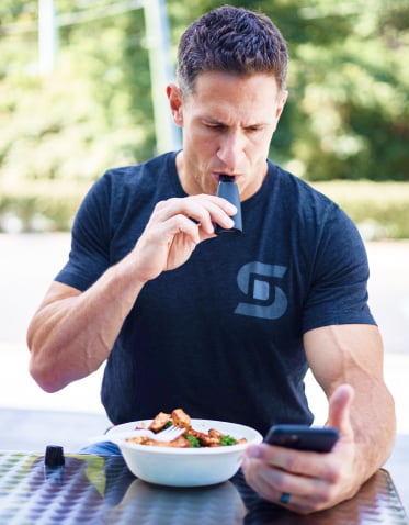 A man blows into a Lumen device looking at a cell phone